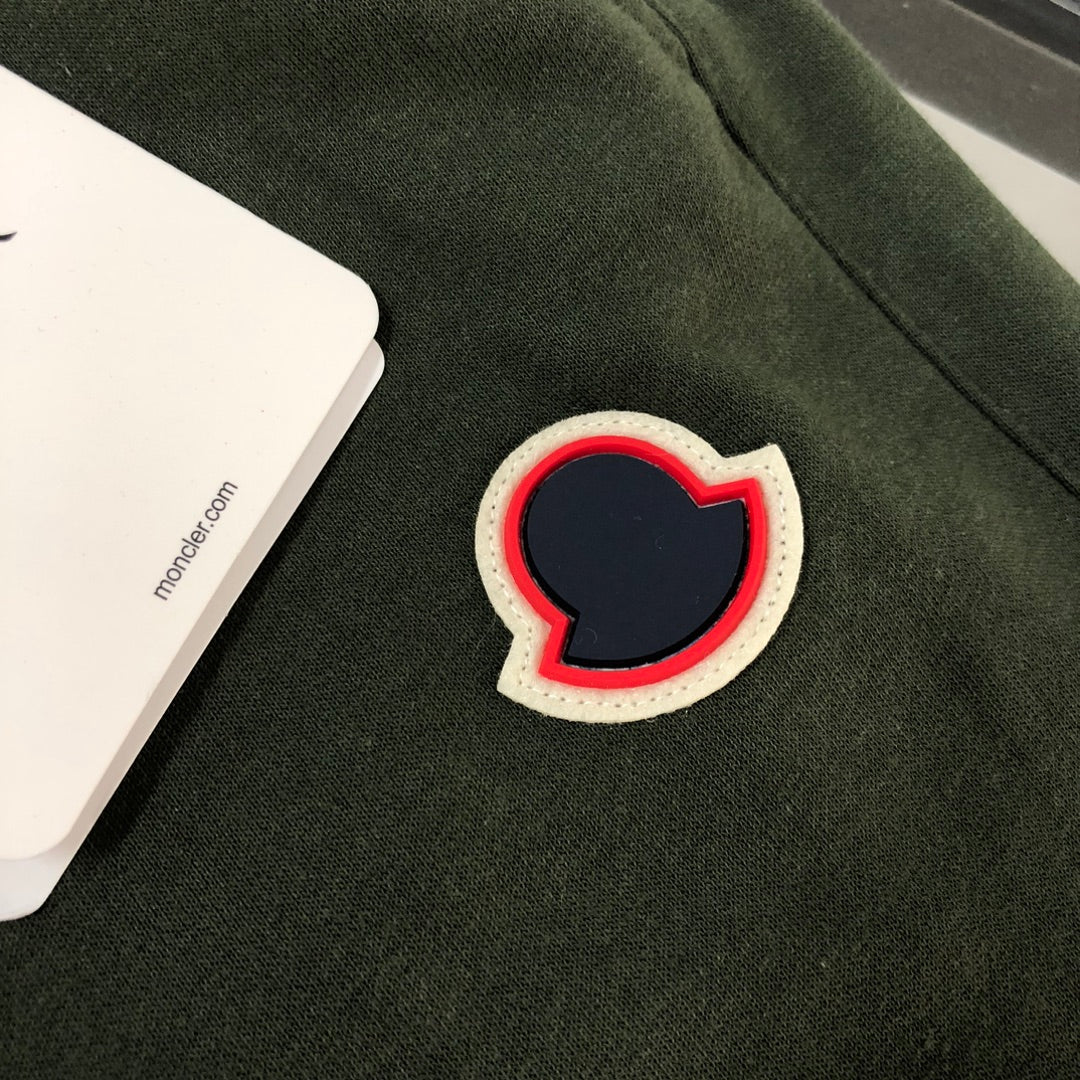 Heart-shaped patch applique with red outline on dark green shorts