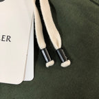 White drawstrings with black cord tips on dark green shorts