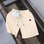 Cream drawstring shorts with elastic waistband and red-outlined heart logo patch
