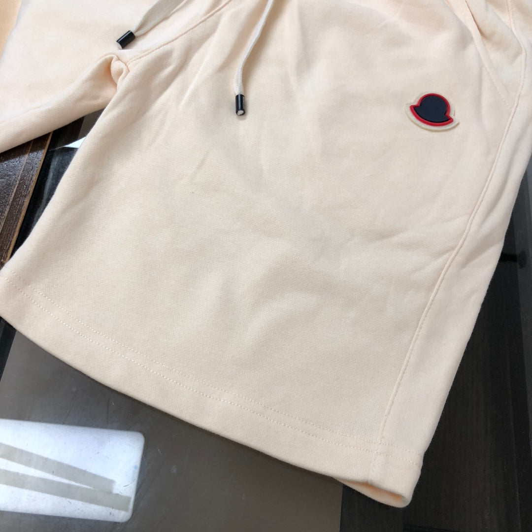 Cream shorts with elastic waistband, side seams, and red-outlined heart logo
