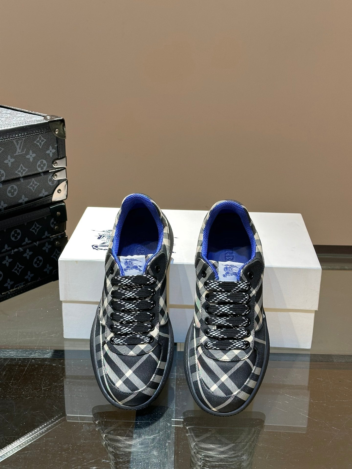 Low-top sneakers with blue interior lining and black and white plaid uppers