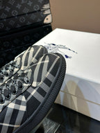 Close-up of plaid sneaker upper with black laces and textured black sidewall