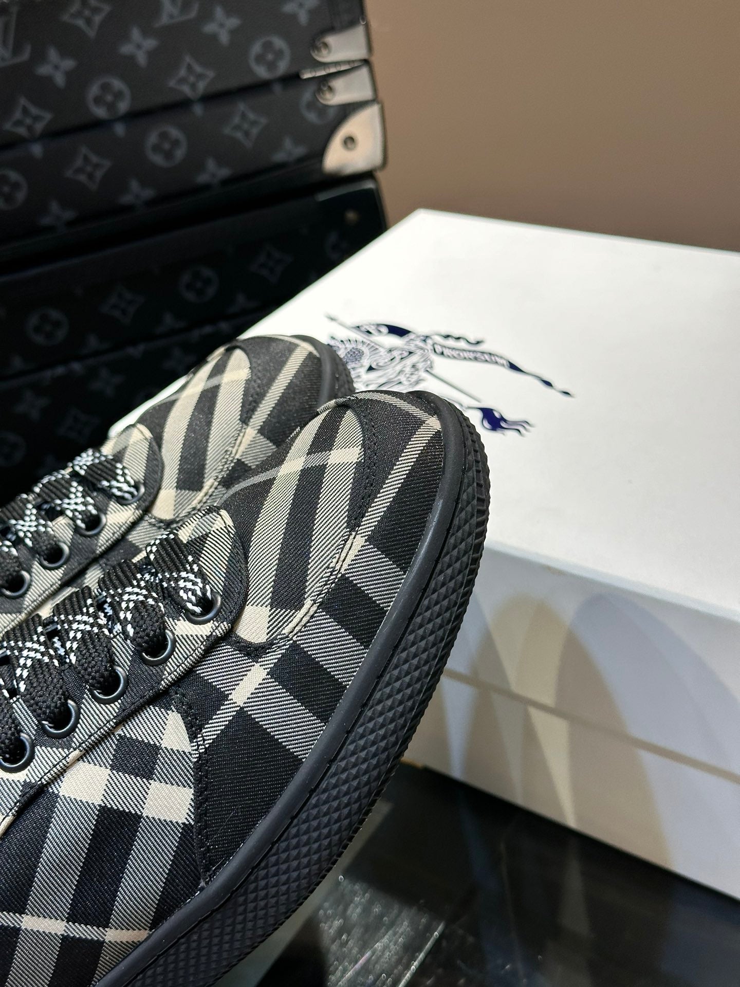 Close-up of plaid sneaker upper with black laces and textured black sidewall