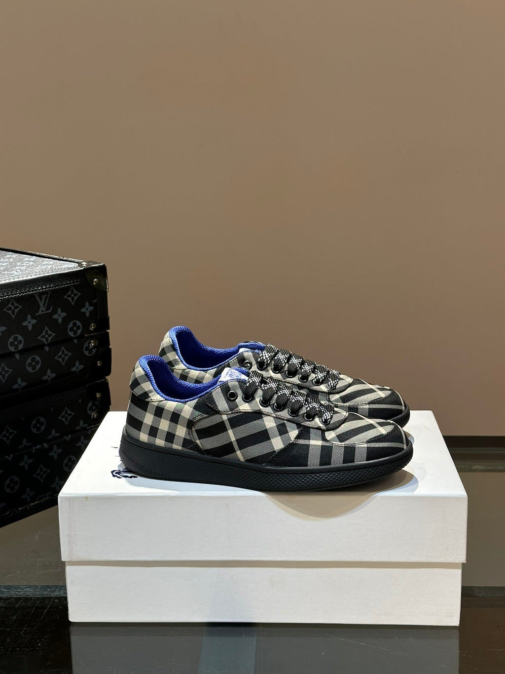 Low-top lace-up sneakers with black and white plaid pattern and blue lining