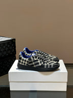 Low-top lace-up sneakers with black and white plaid pattern and blue lining