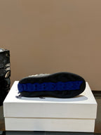 Sneaker outsole with “BURBERRY” text in blue on black rubber