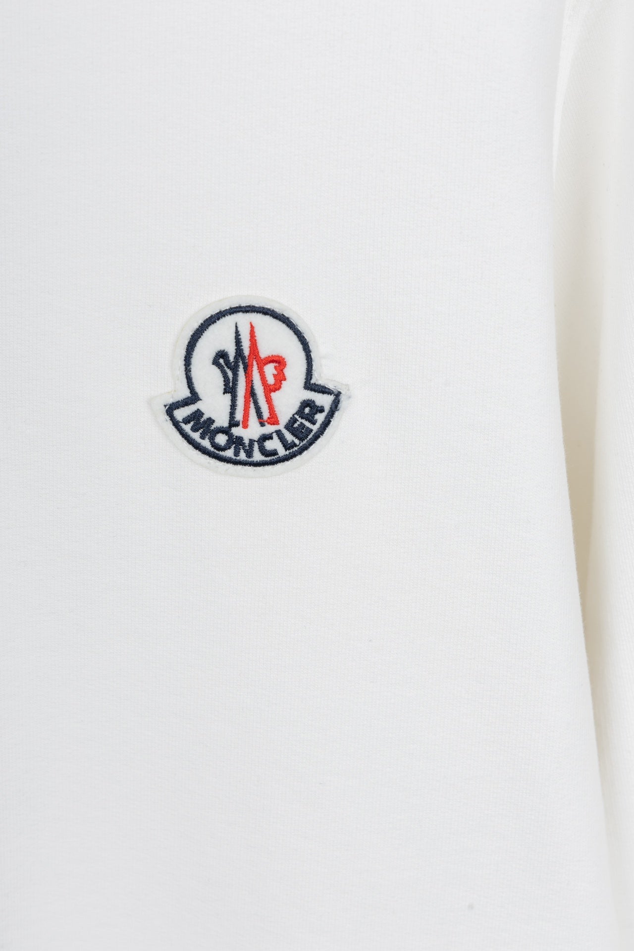 White sweatshirt with embroidered logo patch on the chest