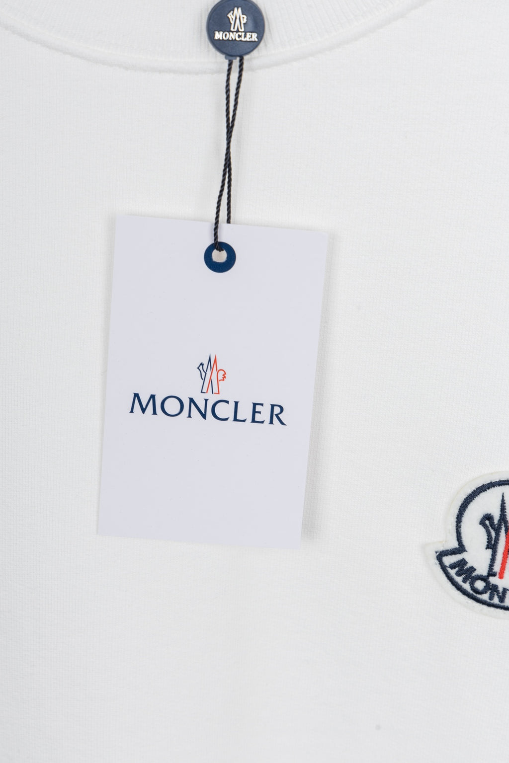 White crew-neck sweatshirt with logo patch and hanging brand tag