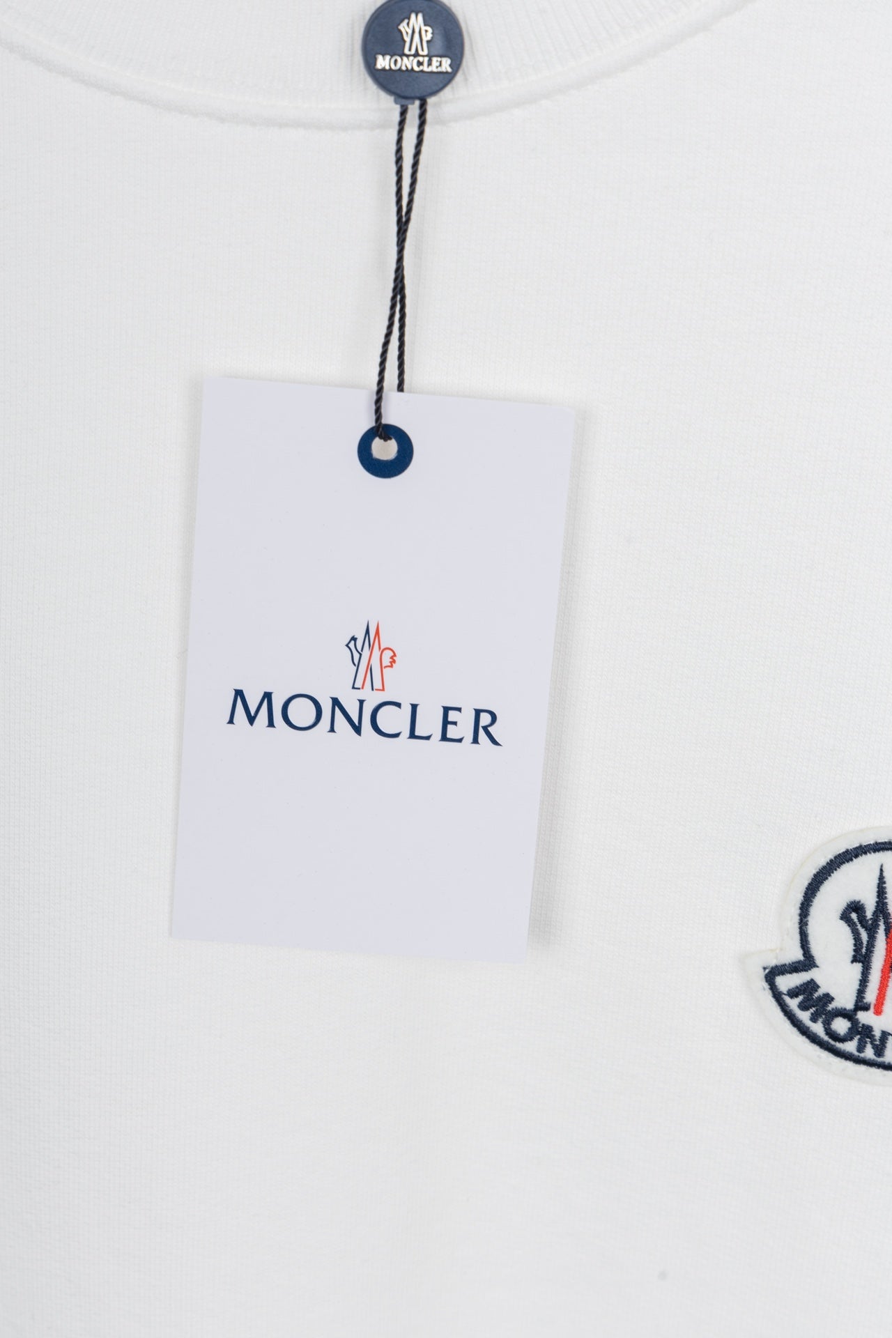 White crew-neck sweatshirt with logo patch and hanging brand tag