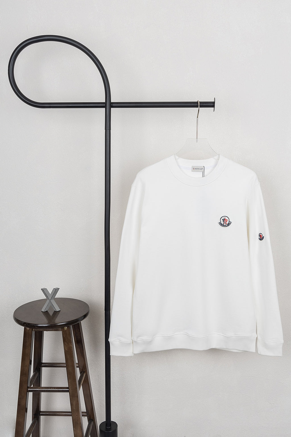 White long-sleeve sweatshirt with crew neck and small chest logo patches