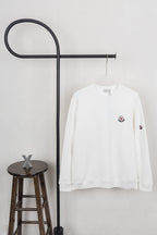 White long-sleeve sweatshirt with crew neck and small chest logo patches