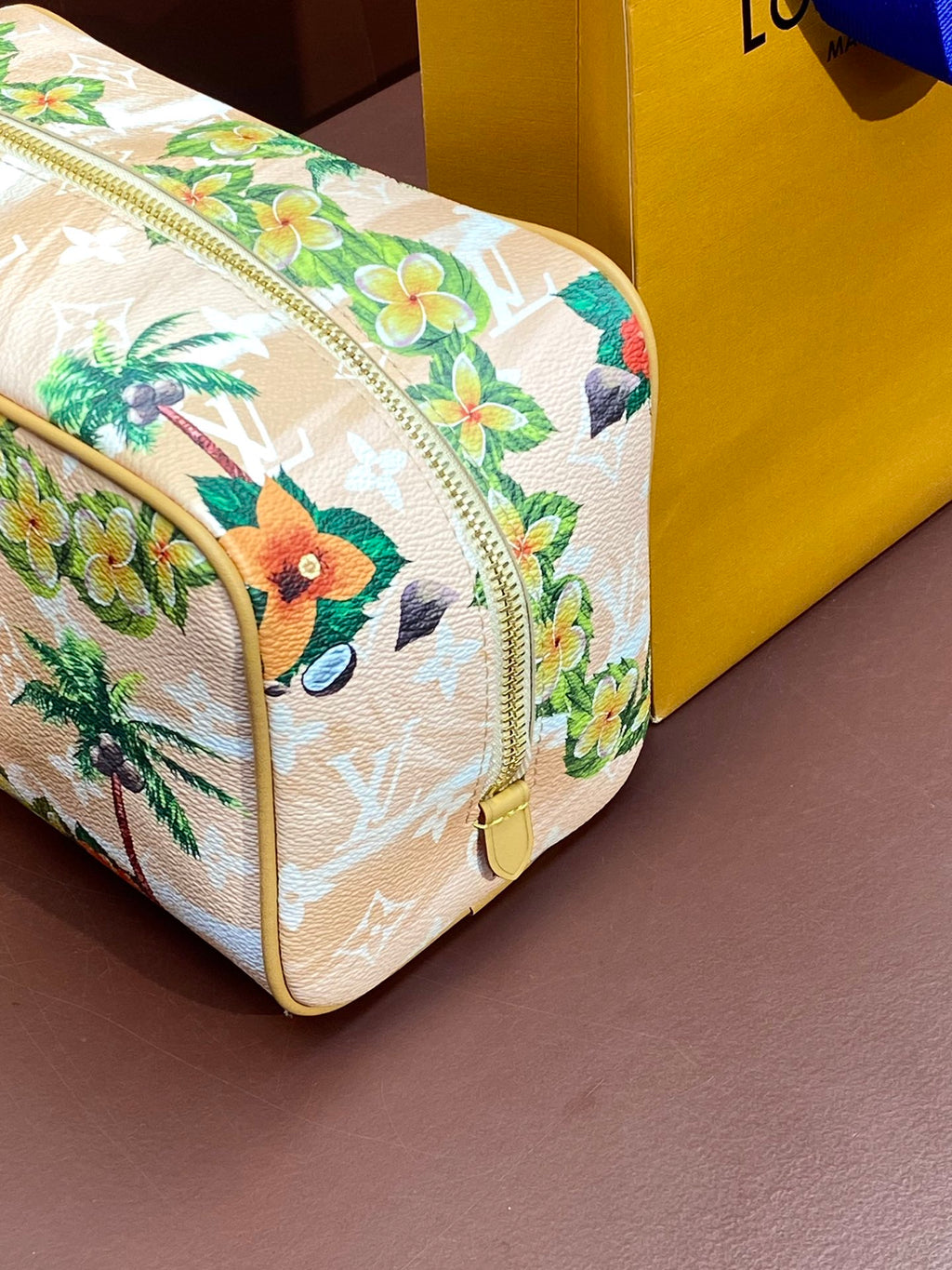 Louis Vuitton mini crossbody bag, floral toucan print, rounded shape, yellow trim.
