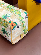 Louis Vuitton mini crossbody bag, floral toucan print, rounded shape, yellow trim.