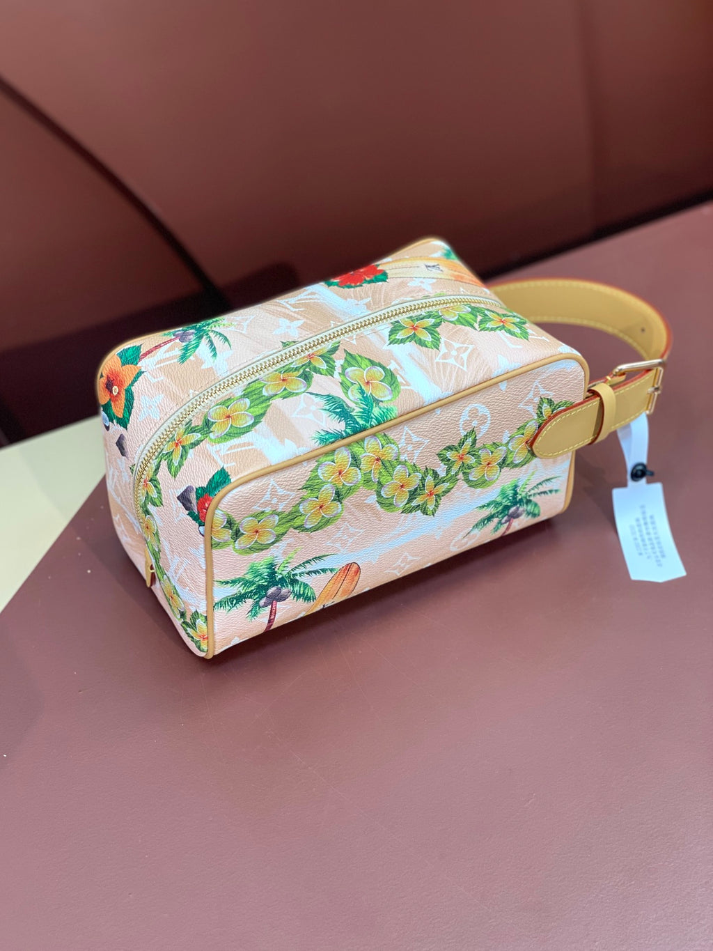 Louis Vuitton mini crossbody bag with floral toucan print, zip top, yellow strap and tag.