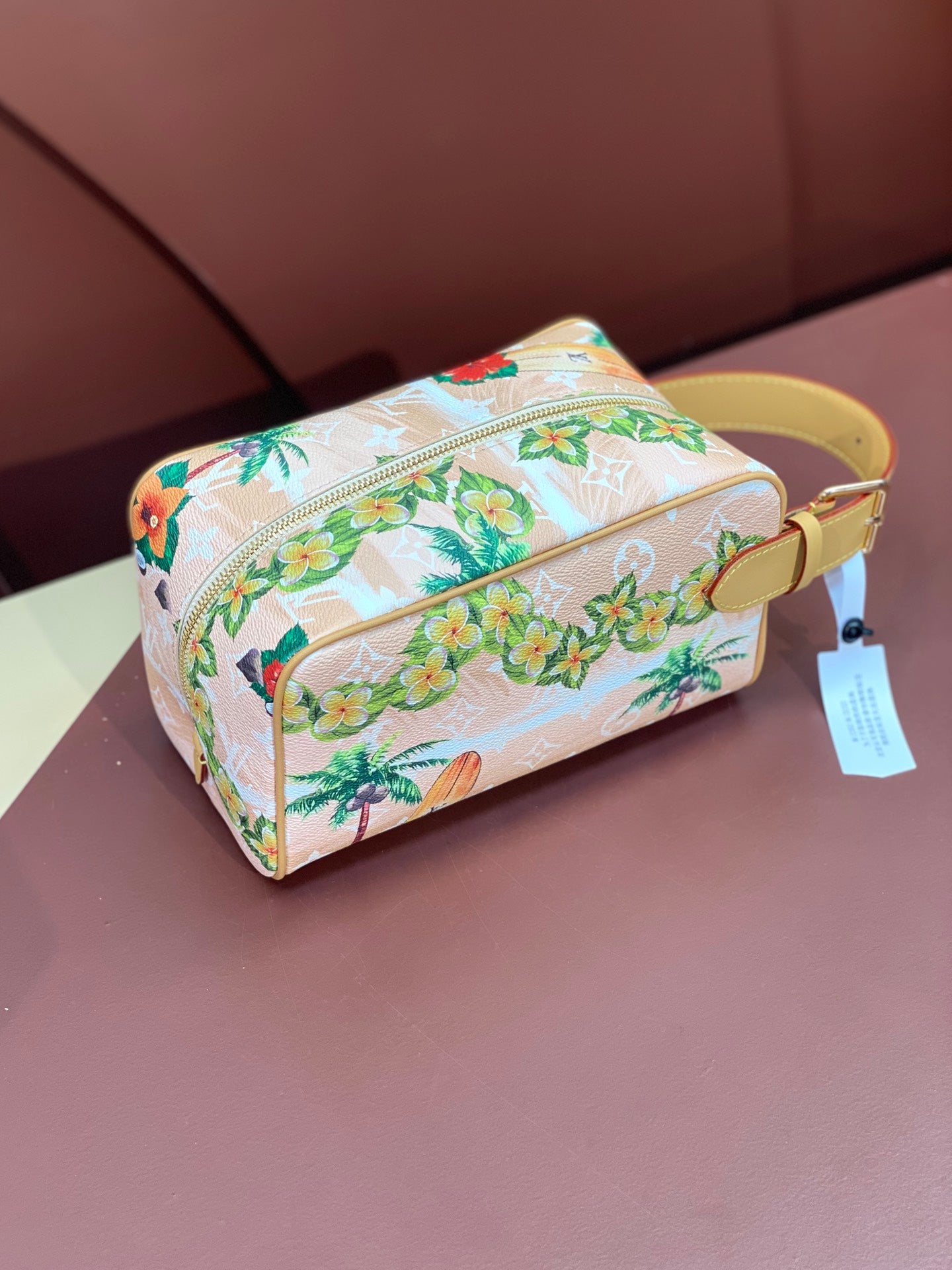 Louis Vuitton mini crossbody bag with floral toucan print, zip top, yellow strap and tag.