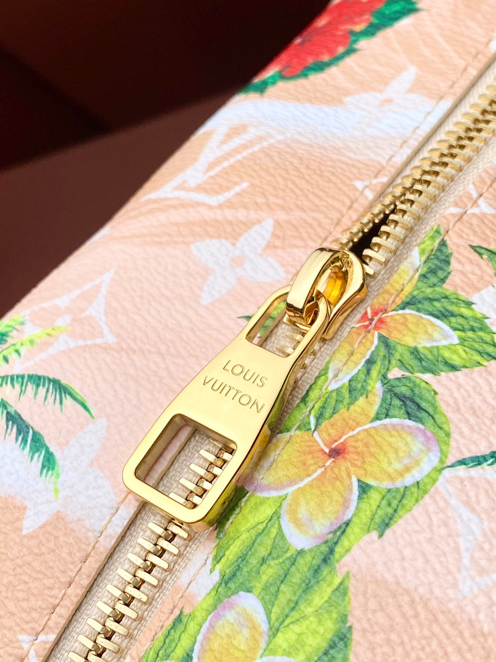 Louis Vuitton zipper pull, floral toucan pattern on light canvas with gold hardware.