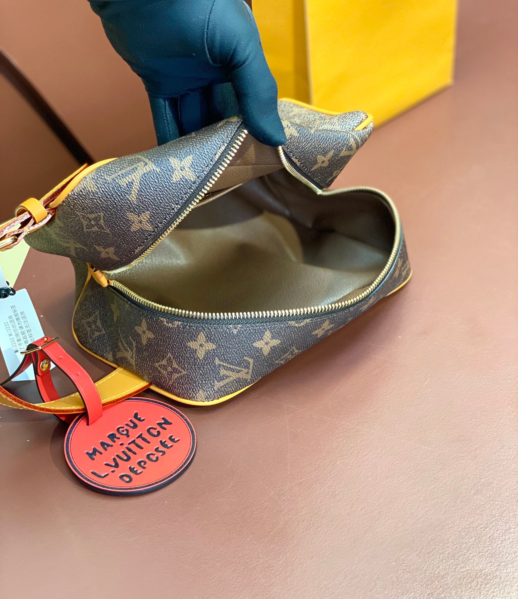 Louis Vuitton bag open top, showing brown monogram interior lining and zipper track