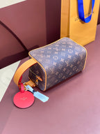 Louis Vuitton bag 3/4 view with tan handle, pink charm tag, and monogram canvas