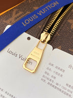 Louis Vuitton bag zipper pull with tan strap label card and blue webbing strap