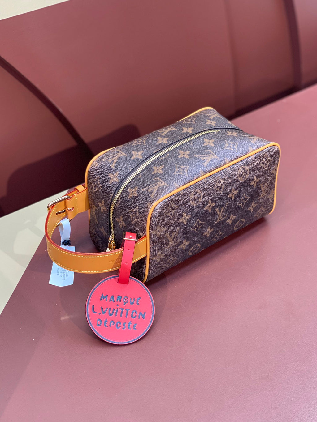 Louis Vuitton bag in brown monogram canvas with tan trim and gold zipper, side view