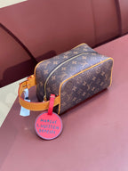 Louis Vuitton bag in brown monogram canvas with tan trim and gold zipper, side view