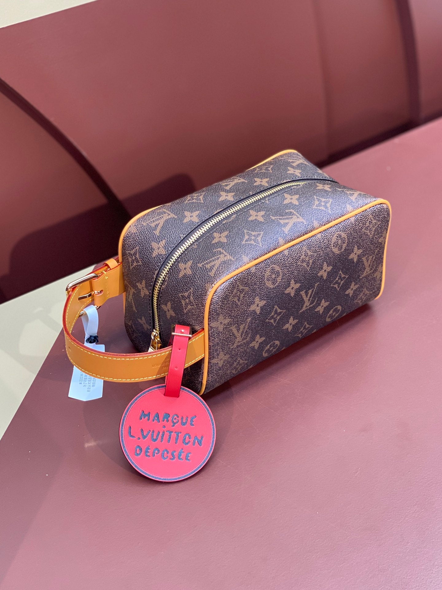 Louis Vuitton bag in brown monogram canvas with tan trim and gold zipper, side view