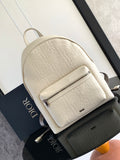 Cream embossed backpack with front zip pocket, top handle, adjustable straps.