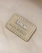Beige label tag with Dior and Made in Italy text on the backpack.