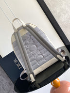 Colorblock backpack in cream and gray with zip closure and adjustable shoulder strap.