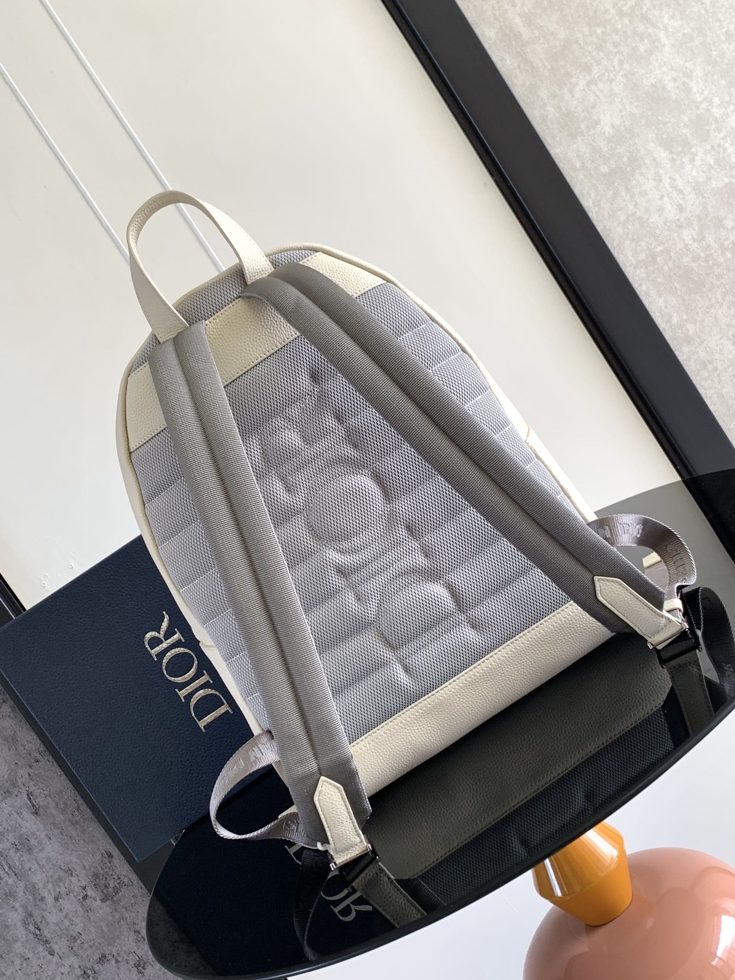 Colorblock backpack in cream and gray with zip closure and adjustable shoulder strap.