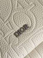 Cream textured fabric with embossed Dior logo lettering.