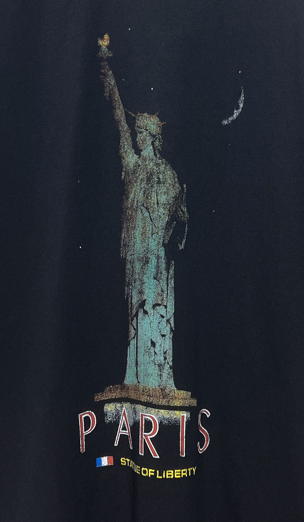 Close-up of dark T-shirt front showing “PARIS” text under the Statue of Liberty print