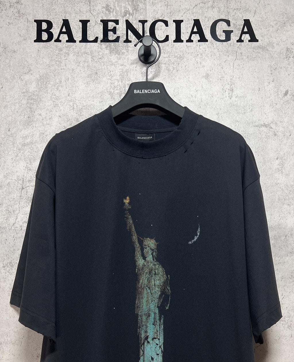 Dark graphic T-shirt front with Statue of Liberty print and small crescent accents