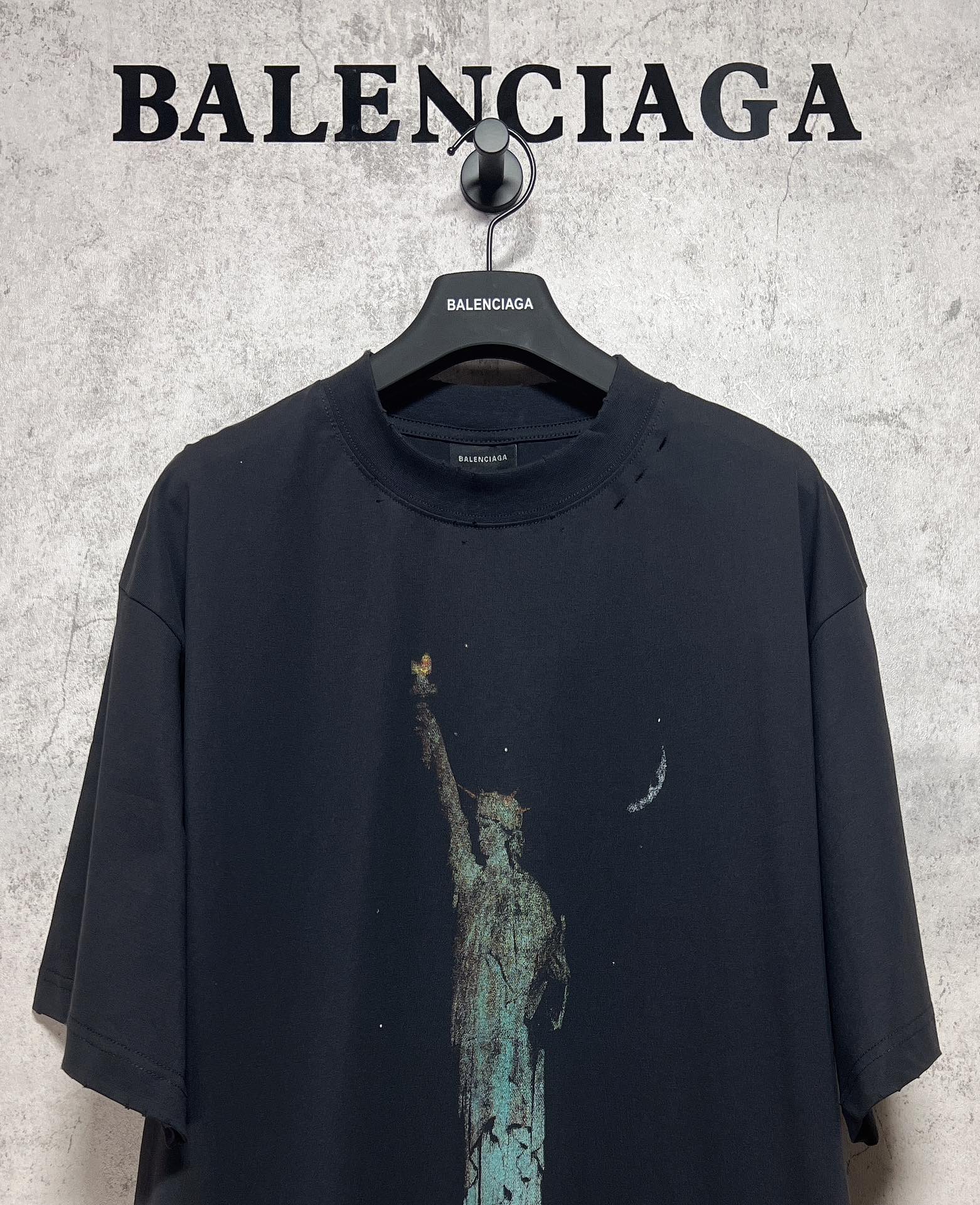 Dark graphic T-shirt front with Statue of Liberty print and small crescent accents