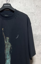 Dark T-shirt with partial Statue of Liberty graphic and speckled print on the front