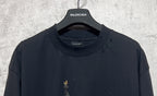 Dark crewneck T-shirt with Balenciaga logo at the collar; small front print flecks