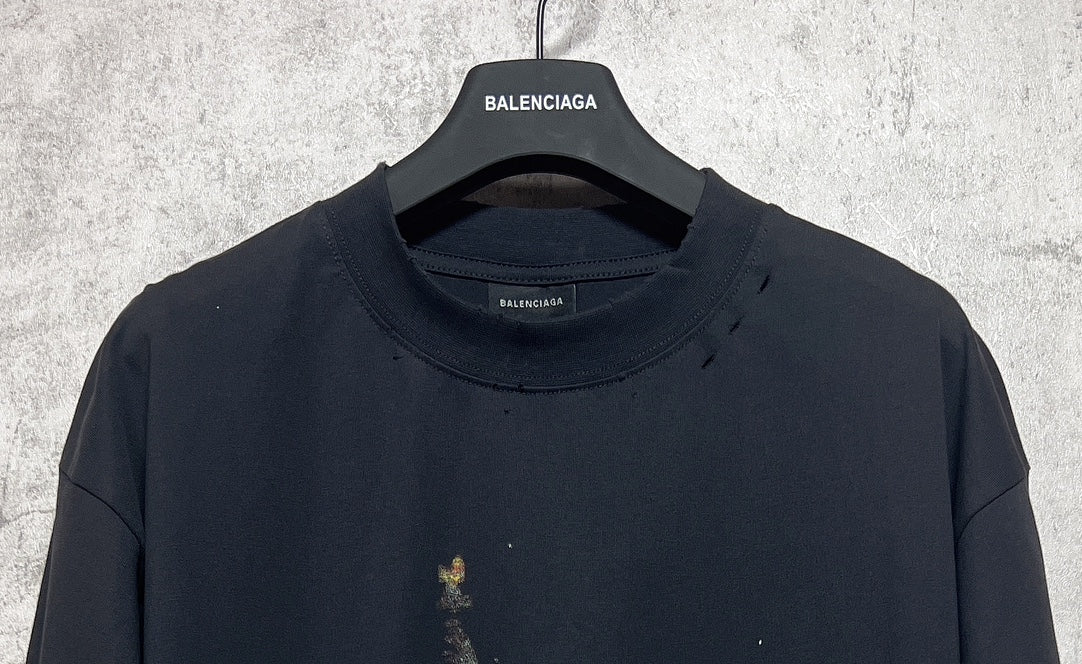 Dark crewneck T-shirt with Balenciaga logo at the collar; small front print flecks