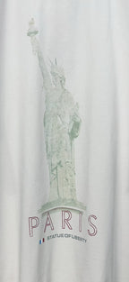 Close-up of white T-shirt featuring green Statue of Liberty and PARIS lettering