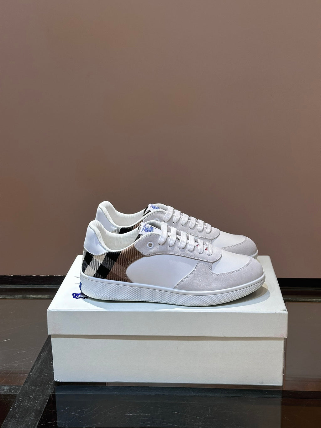 Burberry low-top sneakers in white with blue logo and lace-up front, plaid panel detail