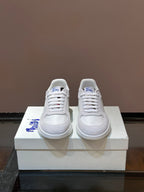 Burberry white lace-up sneakers with blue logo on side and plaid detail at heel