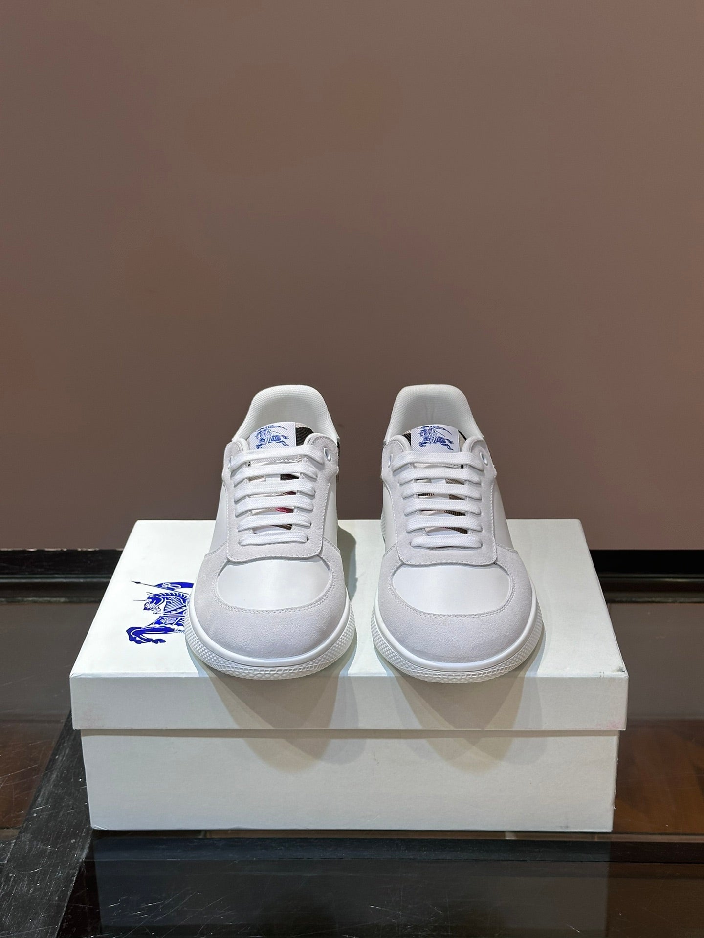 Burberry white lace-up sneakers with blue logo on side and plaid detail at heel