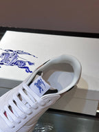Burberry white sneaker close-up with blue logo patch on tongue and lace eyelets