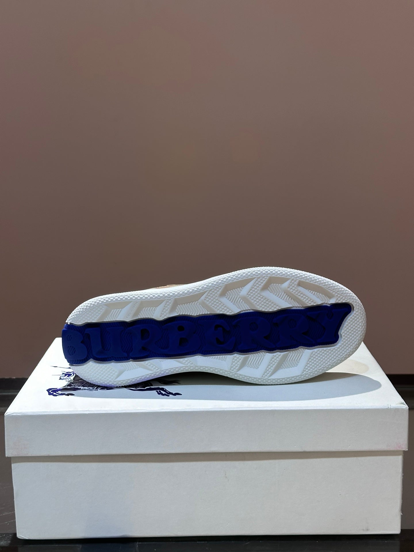 Outsole view of checkered low-top sneakers with blue logo on tread