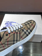 Close-up of checkered sneaker upper with white laces and blue horse logo patch