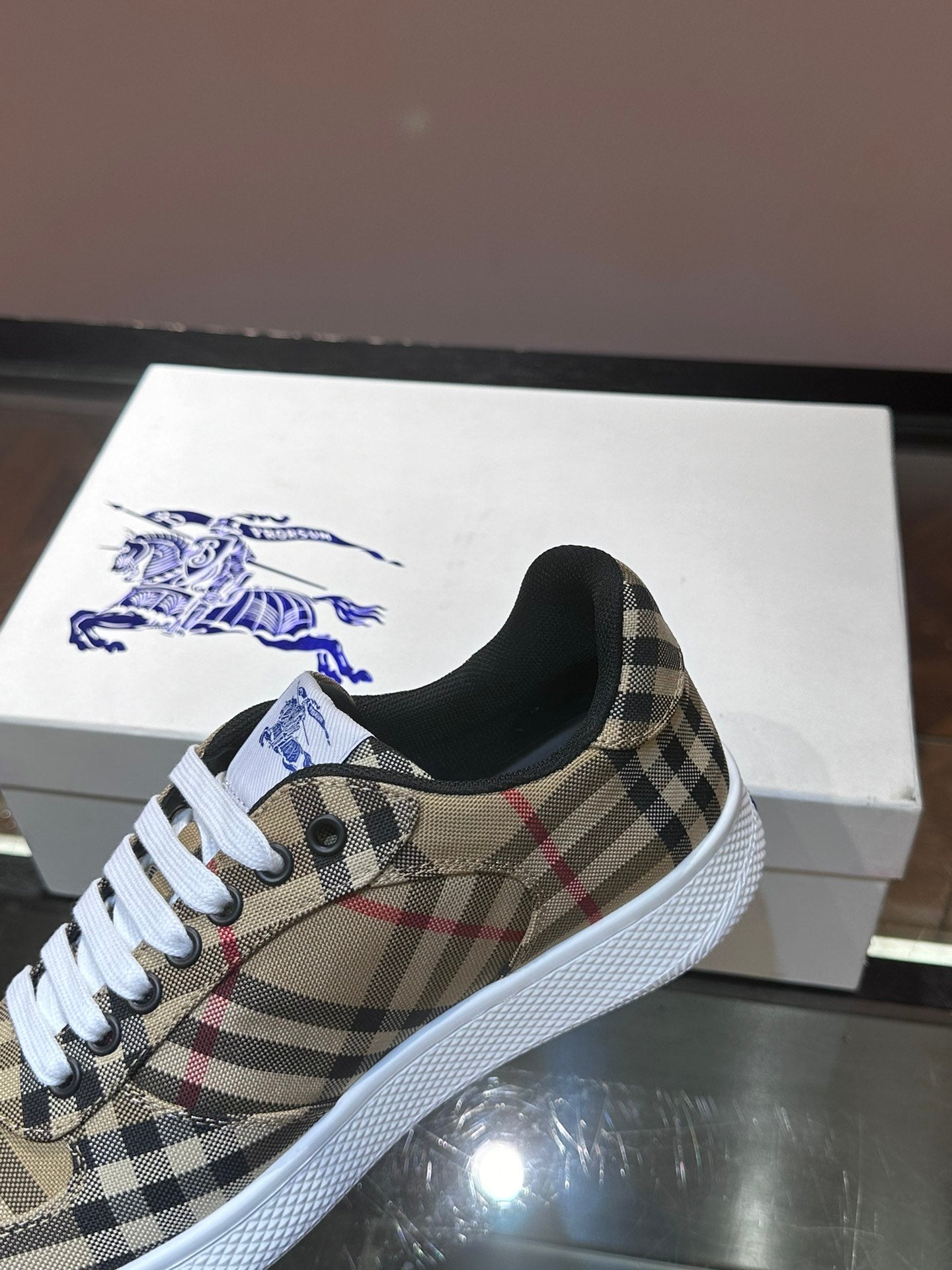 Close-up of checkered sneaker with blue horse logo on side and black interior