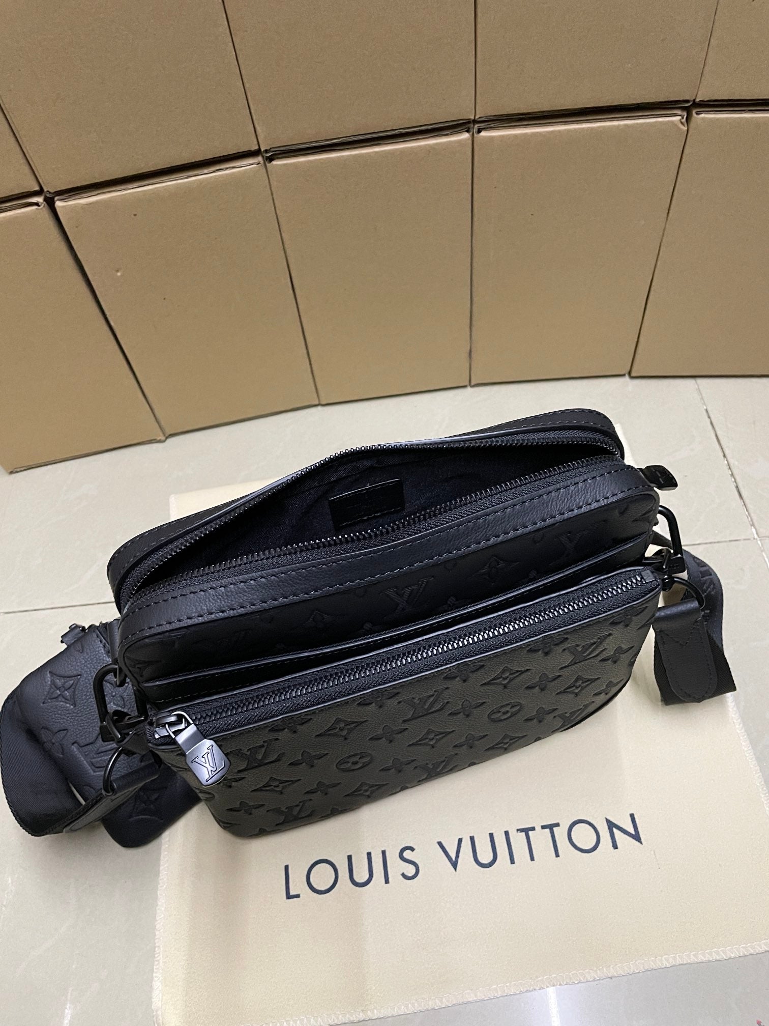 Men's Louis Vuitton crossbody bag, dark blue monogram, front view with dual zip and strap