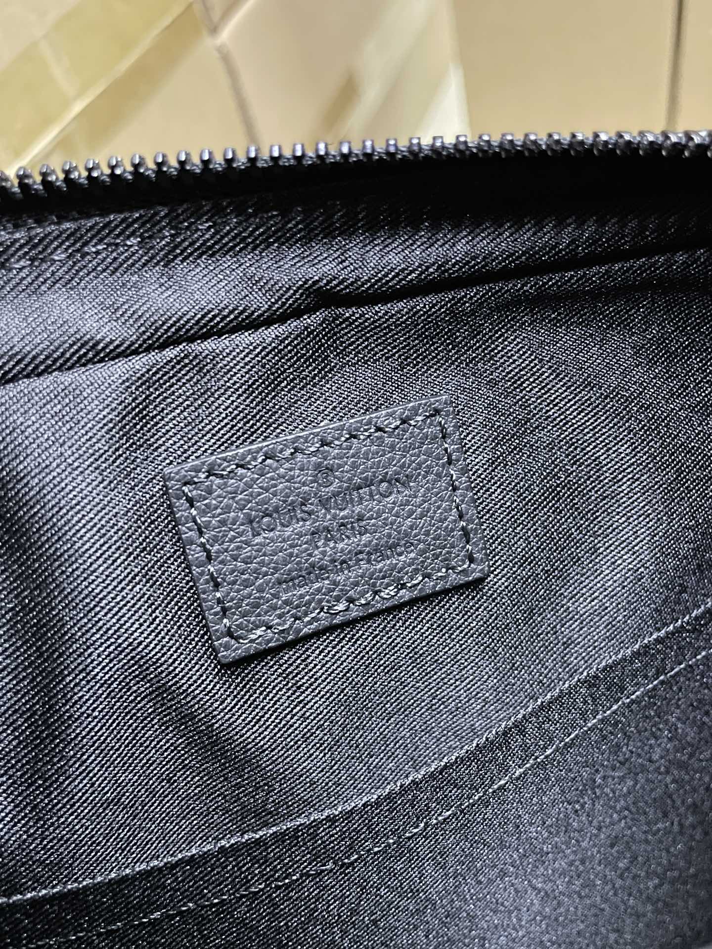 Louis Vuitton fabric pocket with stitched leather patch, dark black tone