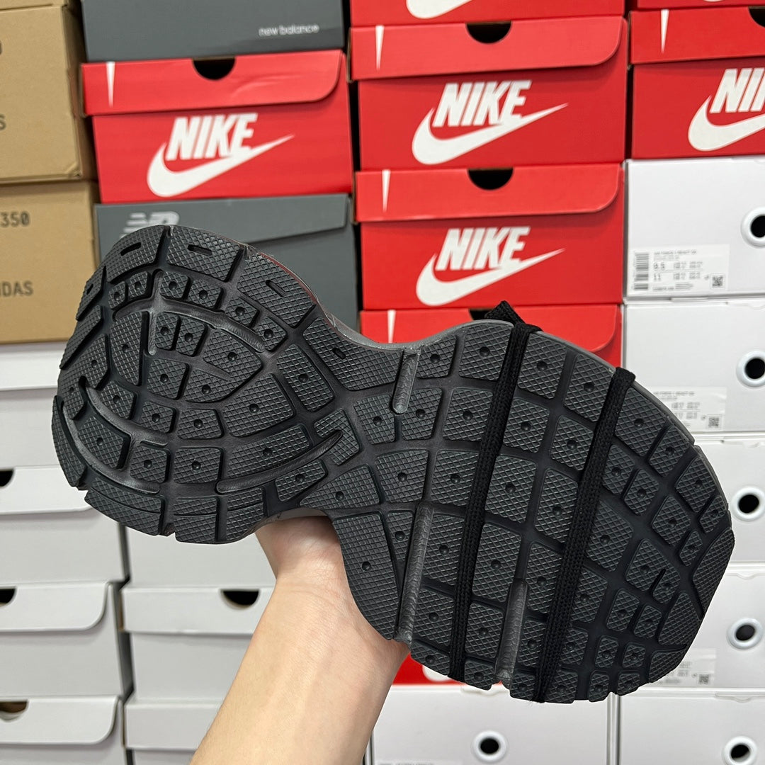 Unisex shoe outsole viewed from below, black rubber tread pattern on chunky sole.