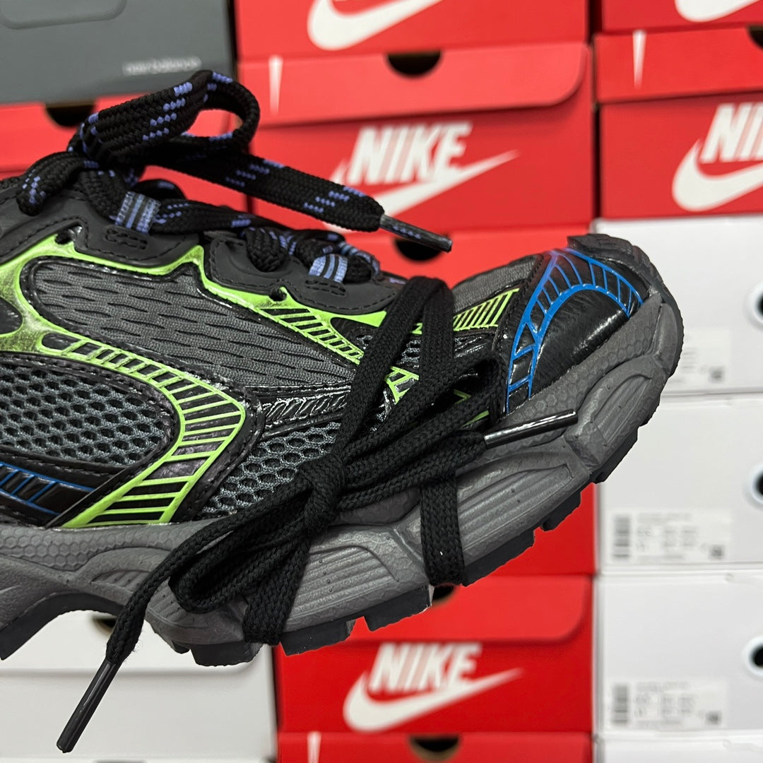 Unisex running shoe side view in black and gray with neon green piping and blue panel.
