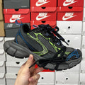 Unisex running shoe in black and gray with neon green and blue accents, lace-up.